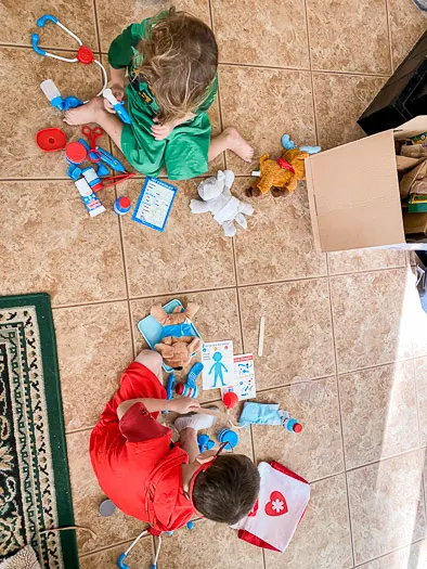 Children sitting on the floor playing with medical toys
