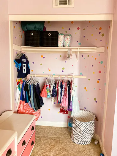 pink multi-polkadotted closet with a low rod hanging holding kids clothes