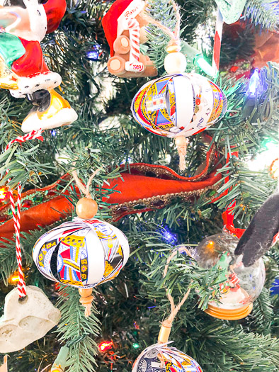 Playing card ornaments hanging on Christmas tree with other ornaments