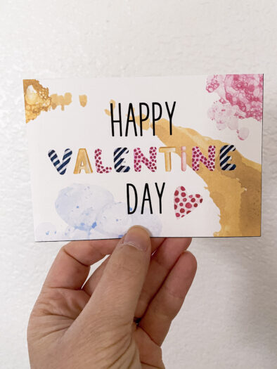 hand holding a post card that says Happy Valentine's Day
