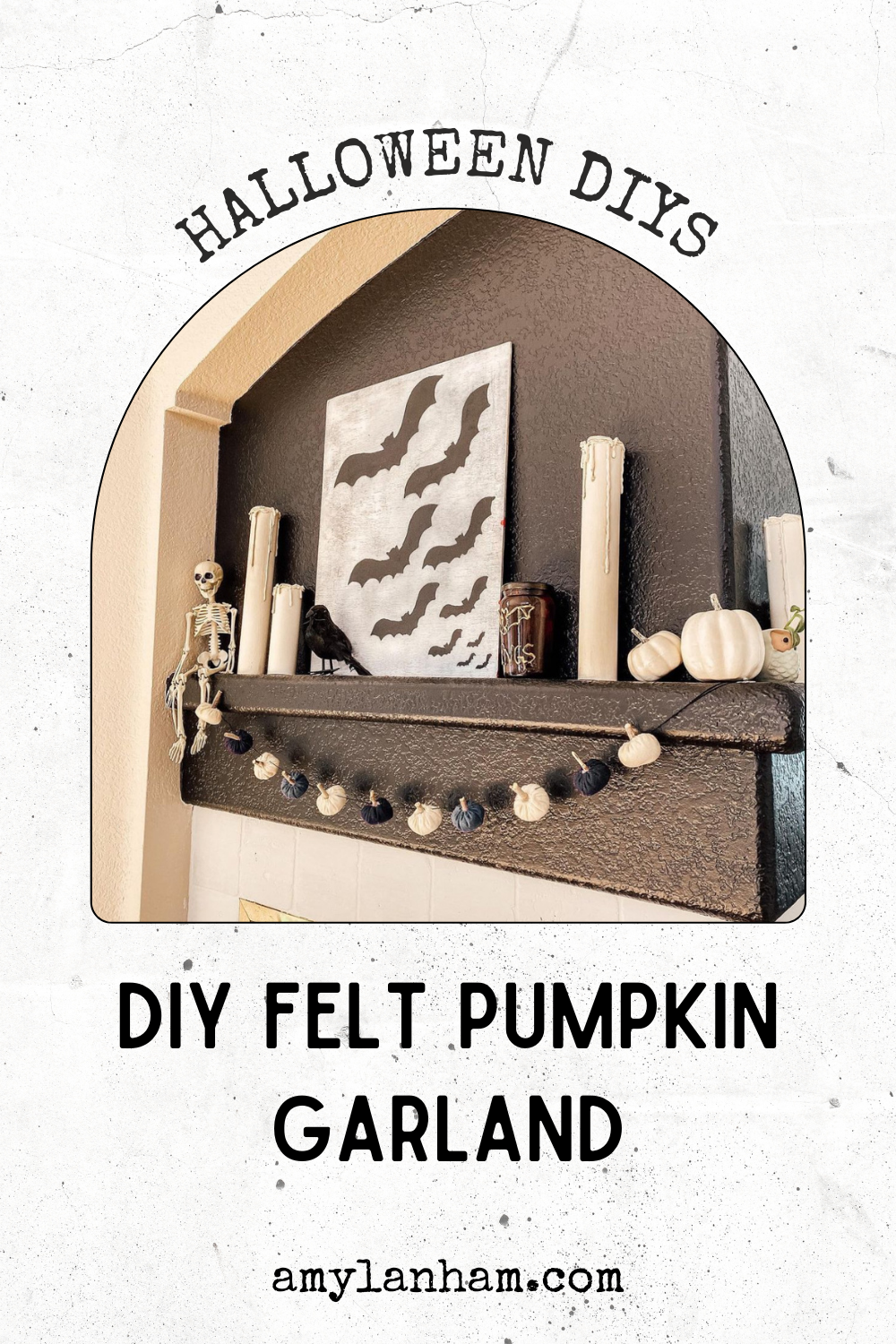 Pumpkin garland hanging on a black fireplace with other halloween decor sitting on the mantel.