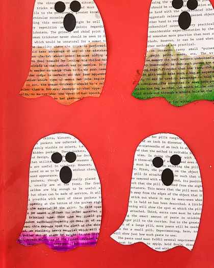 4 book page ghosts on a red tray, top 2 painted, left orange, right green, showing bottom left ghost with water on the bottom half of the ghost and purple painted up 1/4 of the way