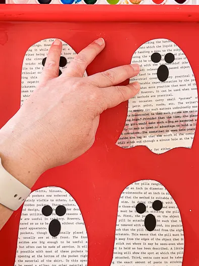 4 book page ghosts on a red tray, showing one ghost with water on the bottom half of the ghost