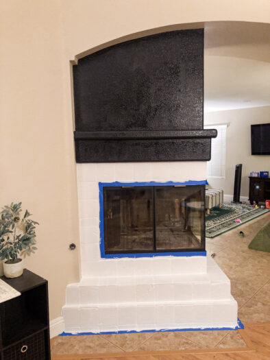 fireplace with surround tile painted white and the top wall painted black