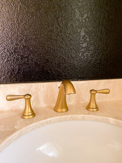 close up of a sink with gold faucet